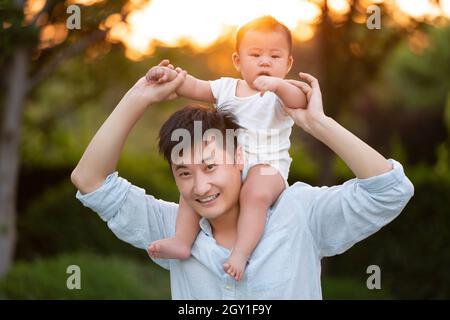 Junger Vater, der sein Baby zum Spielen erzog Stockfoto