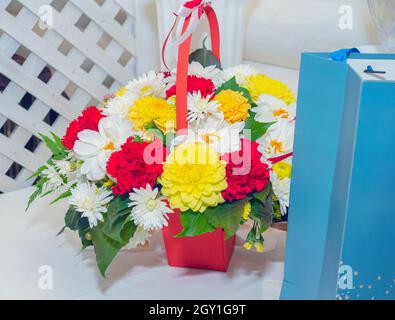 Schöner festlicher Blumenstrauß mit Geschenktüte aus nächster Nähe. Stockfoto