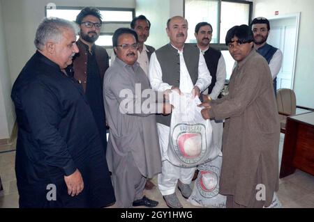 Der Vorsitzende von Hilal Ahmer, Balochistan, Bari Baraich, verteilt während der Zeremonie zur Verteilung der Ration am Mittwoch, den 06. Oktober 2021, im Presseclub Quetta Ration Packs an die Mitarbeiter. Stockfoto