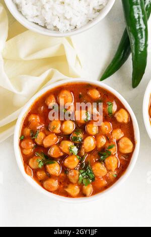 Indische Art gekochte Kichererbsen in Schüssel auf weißem Hintergrund. Vegetarisches veganes Lebensmittelkonzept. Draufsicht, flach liegend Stockfoto