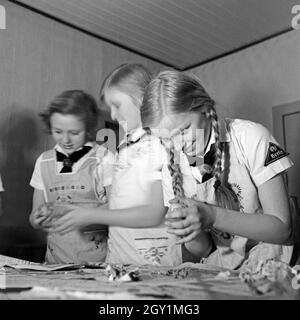 BdM-Mädchen schälen Kartoffeln als Vorbereitung für den Musik- und Heimatabend in Berlin Pankow, Deutschland 1930er Jahre. BdM-Mädchen Schälen von Kartoffeln als Vorbereitung für die Gastronomie einer folcloristic soiree in Berlin Pankow, Deutschland 1930. Stockfoto