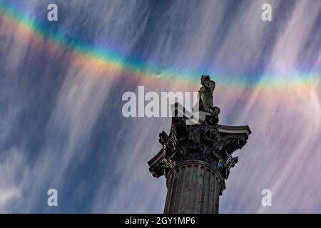 Westminster, London, Großbritannien. Oktober 2021. Am Ende eines herrlich sonnigen Tages mit blauem Himmel hat sich ein Regenbogen in Zirruswolkenformationen über der Nelson-Säule auf dem Trafalgar Square in London gebildet. Kredit: Imageplotter/Alamy Live Nachrichten Stockfoto