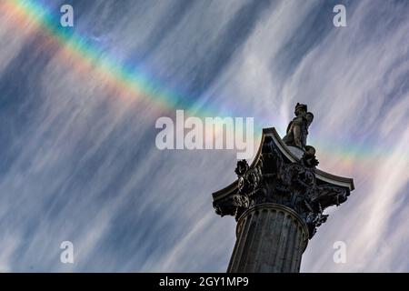 Westminster, London, Großbritannien. Oktober 2021. Am Ende eines herrlich sonnigen Tages mit blauem Himmel hat sich ein Regenbogen in Zirruswolkenformationen über der Nelson-Säule auf dem Trafalgar Square in London gebildet. Kredit: Imageplotter/Alamy Live Nachrichten Stockfoto