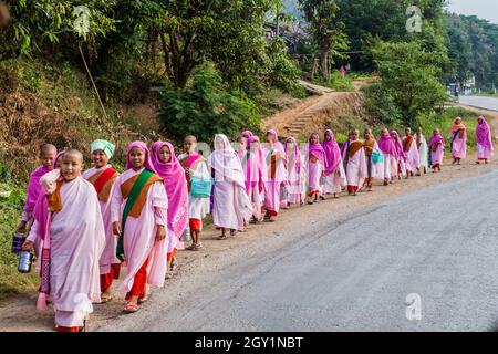 HSIPAW, MYANMAR - 1. DEZEMBER 2016: Junge buddhistische Nonnen gehen in einem Dorf in der Nähe von Hsipaw, Myanmar, zur Almosen Stockfoto