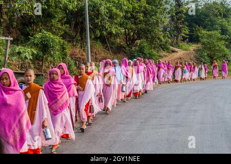 HSIPAW, MYANMAR - 1. DEZEMBER 2016: Junge buddhistische Nonnen gehen in einem Dorf in der Nähe von Hsipaw, Myanmar, zur Almosen Stockfoto