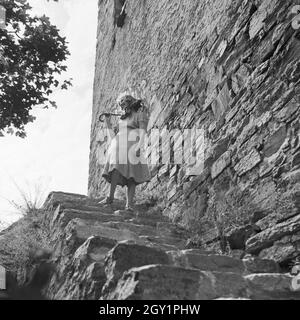 Eine junge Frau steht auf der Treppe eines Bauwerks in Österreich, Deutschland, 1930er Jahre. Eine junge Frau, die auf der Treppe ist ein Meilenstein in Österreich, Deutschland 1930. Stockfoto