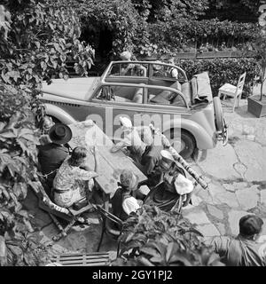 Mit dem Opel zu einem Ausflug in ein Gartenrestaurant, Deutschland 1930er Jahre. Mit einem Opel Cabrio zu einem Garten Restaurant, Deutschland 1930. Stockfoto