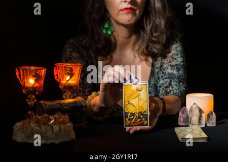 Detail der Hände einer Frau, die die Tarot-Karte des Todes zeigt. Konzept einer Weissagung mit Tarot-Karten. Stockfoto