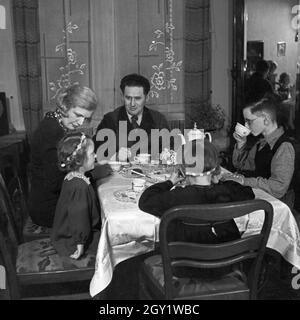 Eine Familie sitzt im Wohnzimmer am Kaffeetisch, Deutschland 1930er Jahre. Eine Familie, die an der Tabele sitzt, Kaffee getrunken, Deutschland 1930er Jahre. Stockfoto