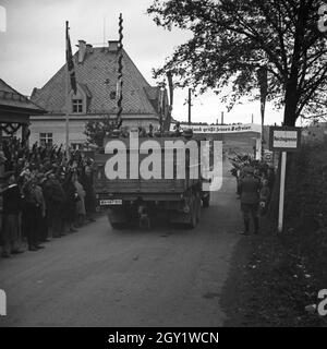 Menschen am Straßenrand jubeln Führer und Reichskanzler Adolf Hitler bei seinem Besuch in Asch im Sudetenland, Deutschland 1930er Jahre. Die Menschen auf den Straßen jubeln dem Führer und Kanzler Adolf Hitler zu, der die Stadt Asch im Sudetenland, Deutschland, in den 1930er Jahren besucht. Stockfoto