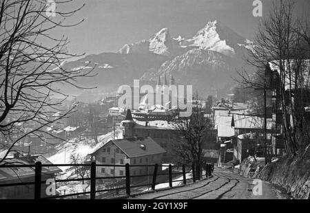 Unterwegs im Berchtesgadener Land, hier: Stadtansicht mit Blick auf die Stiftskirche und die Pfarrkirche, hinter dem Watzmannmassiv, Deutschland 1940er Jahre. Rund um Berchtesgaden, hier: Blick in die Stadt, Deutschland 1940er Jahre. Stockfoto