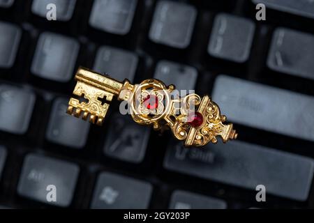 Vintage goldene Taste auf einer schwarzen Tastatur, die alte Passwörter darstellt Stockfoto