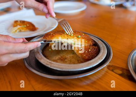 Türkisches Dessert kunefe, kunafa, kadayif mit Pistazien Pulver und Käse, heiß serviert, sehr süß. Türkische traditionelle Dessert Stockfoto