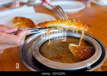 Türkisches Dessert kunefe, kunafa, kadayif mit Pistazien Pulver und Käse, heiß serviert, sehr süß. Türkische traditionelle Dessert Stockfoto