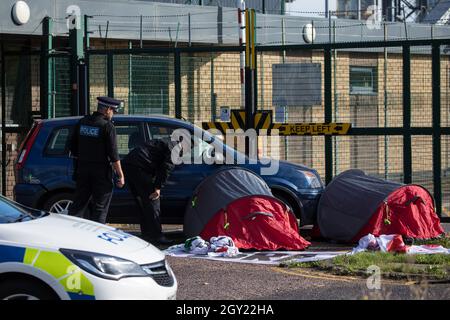 Sandwich, Großbritannien. Oktober 2021. Polizeibeamte von Kent überwachen zwei Aktivisten der Palestine Action in kleinen Zelten, die an einem Auto festgehalten sind, um den Eingang zur Instro Precision-Fabrik im Discovery Park zu blockieren. Instro Precision ist eine Tochtergesellschaft von Elbit Systems, Israels größtem börsennotierten Rüstungsunternehmen, und liefert "hochpräzise militärische Ausrüstung", von der die Palästinensische Aktion behauptet, dass sie vom israelischen Militär gegen die Bevölkerung von Gaza eingesetzt wurde. Kredit: Mark Kerrison/Alamy Live Nachrichten Stockfoto