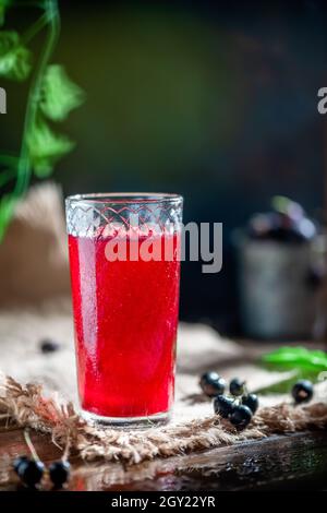 Der Fruchtsaft der Beeren im durchsichtigen Glas. Johannisbeere, Stachelbeere. Gesundes Getränk Stockfoto