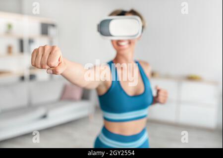 Frau im VR-Headset zu Hause trainieren, Boxen Stockfoto