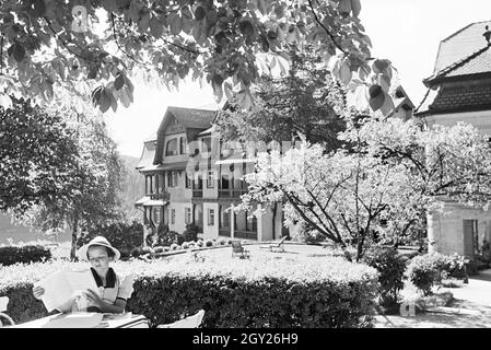 Eine junge Frau entspannt bei der Zeitschriftenlektüre im Garten, Freudenstadt, Deutschland 1930er Jahre. Eine junge Frau bei einem Magazin im Garten, Freudenstadt, Deutschland 1930. Stockfoto