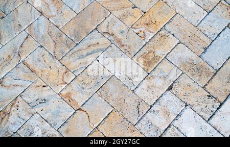 Graue weiße Ziegelsteinpflaster an der Seitenwand. Auf dem Bürgersteig wurden Steine gelegt. Gebäude Textur flache Wand. Stockfoto