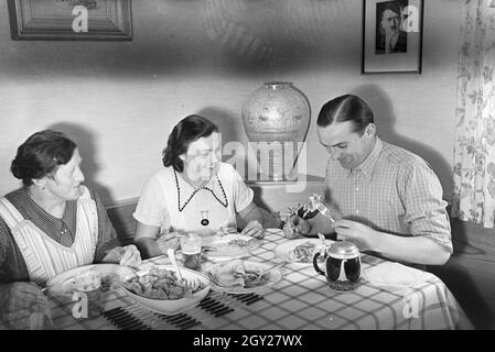 Der autorennfahrer Hermann Lang beim Essen mit seiner Familie, Deutschland 1930er Jahre. Der Rennfahrer Hermann Lang ein Mittagessen mit seiner Familie, Deutschland 1930. Stockfoto