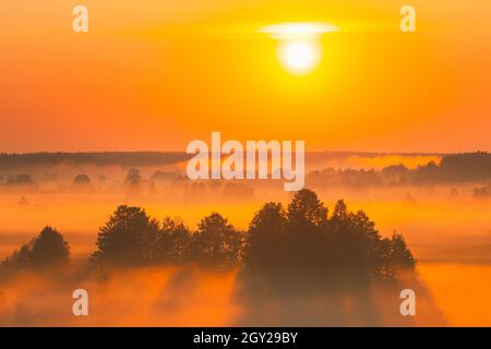 Toller Sonnenaufgang Sonnenuntergang Über Der Misty Landschaft. Landschaftlich Schöner Blick Auf Den Nebligen Morgenhimmel Mit Aufgehender Sonne Über Dem Misty Forest Und Dem Fluss. Frühsommer Natur Von Stockfoto