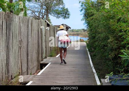 Mann, der während der Sommerferien auf der Promenade in Cherry Grove, Fire Island, New York, USA, läuft. Stockfoto