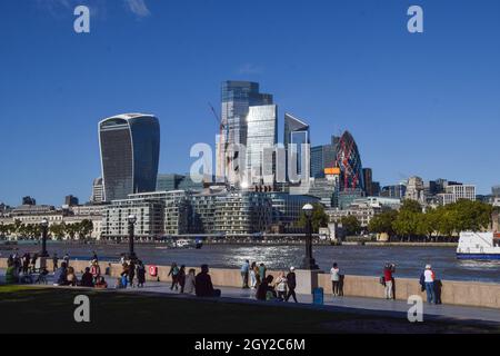 London, Großbritannien. Oktober 2021. Die Menschen entspannen sich an einem klaren Tag entlang der Promenade von Queen's Walk mit dem allgemeinen Blick auf die Skyline der City of London. Kredit: SOPA Images Limited/Alamy Live Nachrichten Stockfoto