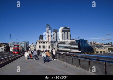 London, Großbritannien. Oktober 2021. Die Menschen laufen an einem klaren Tag entlang der London Bridge mit dem allgemeinen Blick auf die Skyline der City of London. Kredit: SOPA Images Limited/Alamy Live Nachrichten Stockfoto