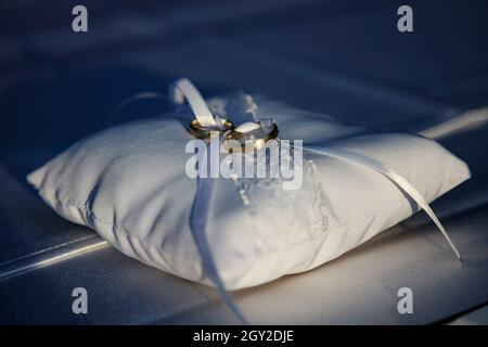 Ehering, Symbol für Liebe und Ehe. Eheringe kreative Makro- und Nahaufnahmen. Schöne goldene Ringe mit Edelsteinen. Stockfoto