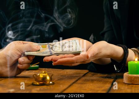 Ein Wahrsager oder orakel nimmt Geld für seine Arbeit. Wahrsagerei von Hand, Geromantie. Psychische Lesungen und das Konzept der Hellsichtigkeit. Stockfoto