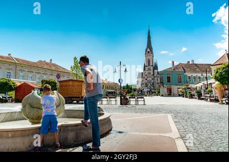 KOSZEG, UNGARN - 14. AUGUST 2021: Blick auf die Herz-Jesu-Kirche oder Koszegi Jezus szive plebaniatemplom und die Menschen auf dem Main Squre oder Fo ter o Stockfoto