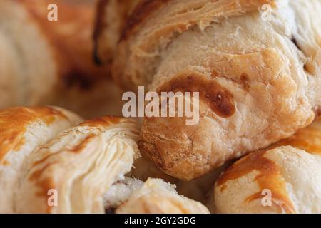 Makroaufnahme von knusprigen Croissants. Frische braune Croissants, beliebte Frühstücks- oder Mittagszutaten in französischer Kultur. Selektiver Fokus. Stockfoto