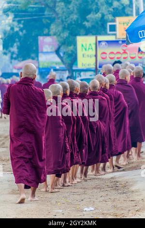 BAGAN, MYANMAR - 8. DEZEMBER 2016: Reihen buddhistischer Mönche sammeln ihre täglichen Almosen. Stockfoto