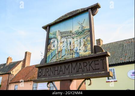 Holzschild für den Burnham Market mit einer alten, traditionellen Marktszene. Norfolk, England. Stockfoto