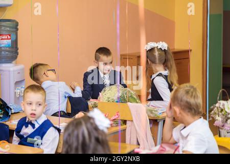 Zwei Erstklässler wetteifern in ihren Armen. Schule, Wissenstag. Moskau, Russland, 1. September 2021 Stockfoto