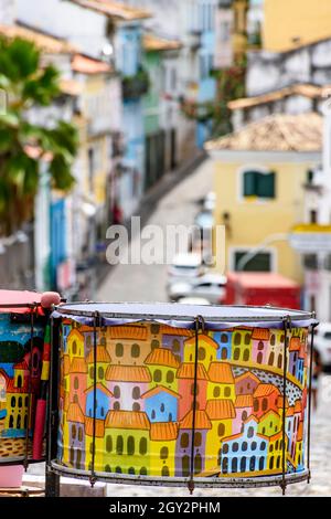 Dekoriert Trommeln mit den Straßen und Hängen des berühmten und historischen Pelourinhoviertel in Salvador im Hintergrund Stockfoto