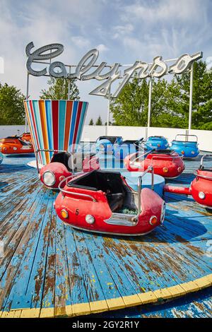 Verlassene Autos mit roten Stoßfängern im Themenpark auf einer abblätternden blauen Basis Stockfoto