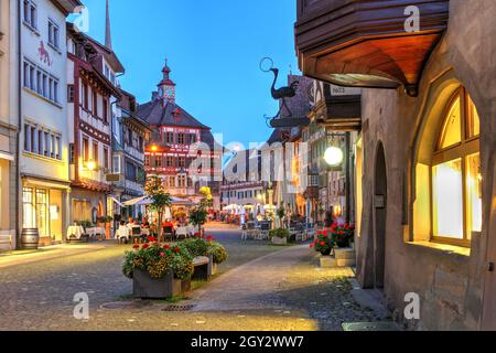 Sommerabend in Stein am Rhein entlang des Rathausplatzes, mit dem Rathaus am anderen Ende. Stein am Rhein ist eine historische Stadt westlich des Bodensees ( Stockfoto