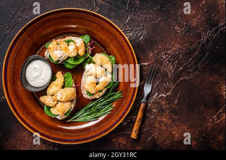 Sandwiches mit gebratenen Garnelen, Garnelen, Spinat und Mangold-Salat auf einem rustikalen Teller. Dunkler Hintergrund. Draufsicht. Speicherplatz kopieren Stockfoto