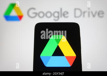 In dieser Abbildung ist ein Google Drive-Logo auf einem Smartphone und einem pc-Bildschirm zu sehen. Stockfoto