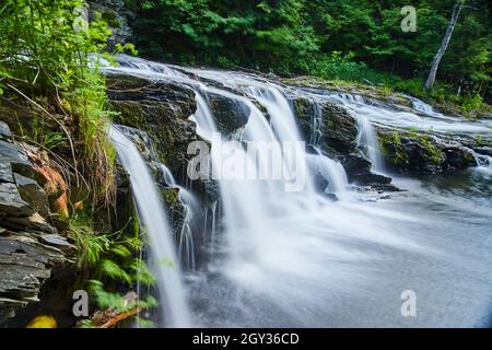 Seitenansicht aus der Nähe von Wasserfällen, die durch Felsformationen im Wald schneiden Stockfoto