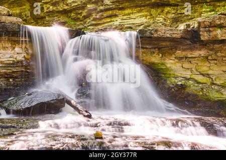 Nahaufnahme eines Wasserfalls, der gegen Felsen spritzt Stockfoto