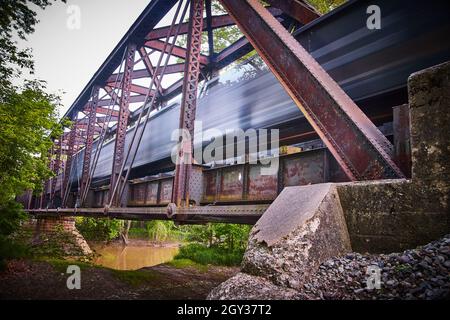Unschärfe des Zuges, der durch eine große Metallbrücke fährt Stockfoto