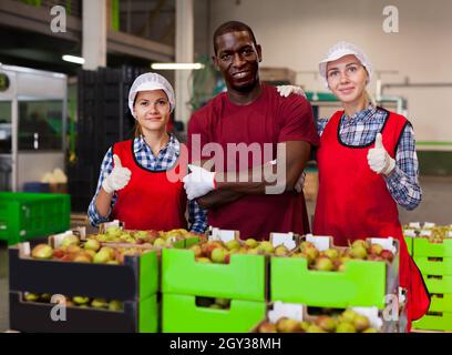 Fröhliche Weibchen und Männchen stehen in der Nähe von Boxen Stockfoto