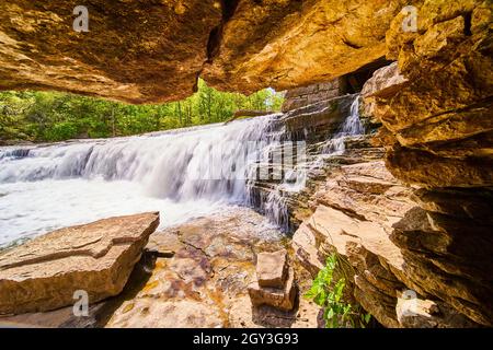 Blick auf den großen Wasserfall von innen auf die kleine Felsenhöhle Stockfoto