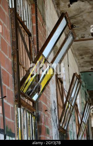 Verrostete Vintage-Trichterfenster kippen in einem alten, verlassenen Gebäude nach innen. Stockfoto