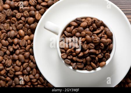 Weißer Kaffeebecher gefüllt mit Kaffeebohnen Stockfoto
