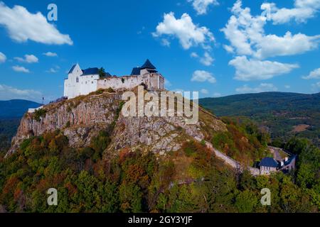 Füzér, Ungarn - Luftaufnahme des berühmten Schlosses von Fuzer, das auf einem vulkanischen Hügel namens Nagy-Milic erbaut wurde. Zemplen Berge im Hintergrund. Winterland Stockfoto