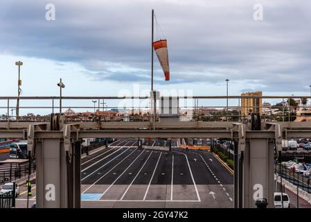 Los Cristianos, Spanien - 9. August 2021: Parkplatz für Einstiegfahrzeuge im Fährhafen am Hafen von Los Cristianos. Teneriffa, Kanarische Inseln Stockfoto