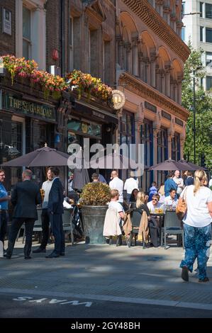 Stadtarbeiter genießen an einem warmen, sonnigen Tag vor dem Sugarloaf Pub ein Getränk zur Mittagszeit. Cannon Street, City of London, England, Großbritannien. Stockfoto